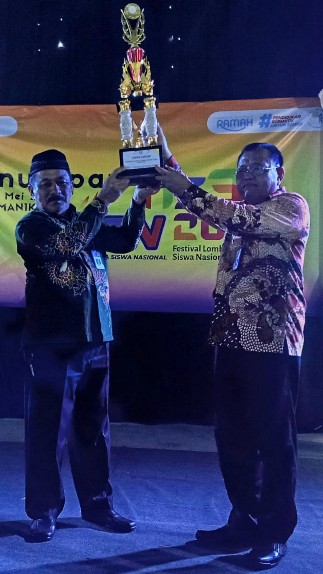 Kepala SMAN 1 Sumenep Drs. Rafiudin, M.Pd, saat menerima Tropy Juara Umum yang diserahkan langsung oleh Kepala Cabang Dinas Pendidikan Provinsi Jawa Timur Wilayah Kabupaten Sumenep Dr. Budi Sulistyo, S.Pd., M.Si