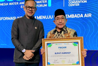 Wakil Bupati saat menerima penghargaan Bupati Sumenep berkat komitmennya dalam pembiayaan dan pengembangan BUMD Air Minum