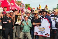 SOLID. Haji Fathor Rosi yang familiar disapa Haji Rosi bersama timnya berpose dengan piala juara pertama Kerapan Sapi Kapolres Sumenep Cup 2025 di Lapangan Kerapan Sapi Sumenep