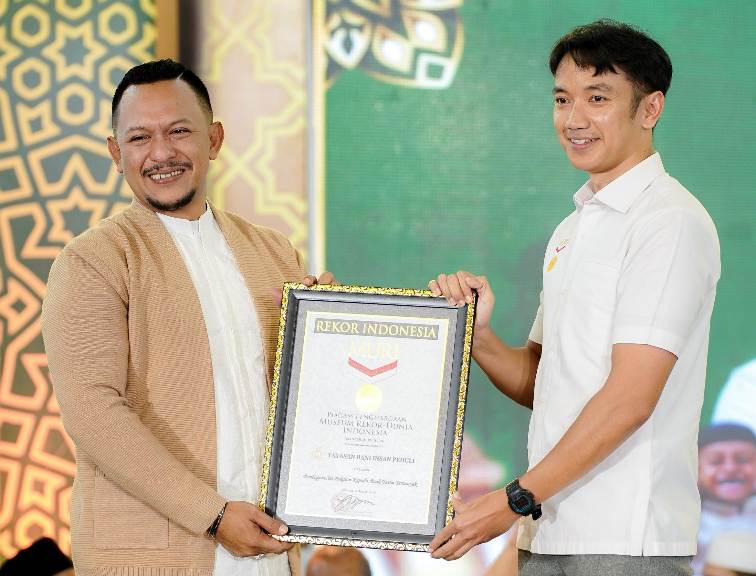 Founder BIP, Ali Zainal Abidin (kiri) saat menerima piagam rekor MURI atas penyelenggaraan buka puasa dan belanja gratis bersama 3.000 anak yatim di Pamekasan
